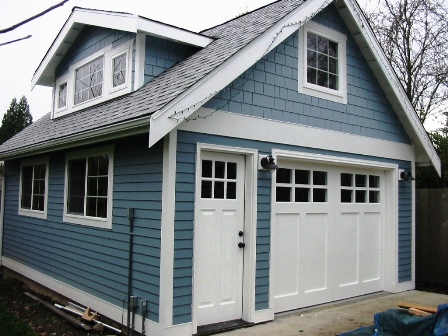 Seattle Custom Garage Doors for a carriage door garage.  Made with a corresponding entry door.  Note the symetrical alignment of all craftsman style door elements.